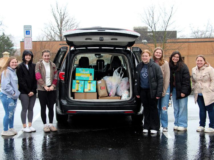 Members of the HDFS club at Penn State DuBois stand next to the vehicle loaded with their donation items prior to their trip to the Hello Neighbor location in Pittsburgh.